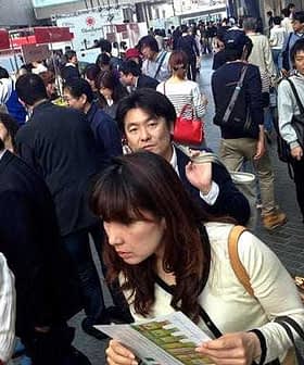 A crowd of people walking in a public area with various individuals visible in the foreground and background. - Olive Oil Times