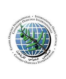 Logo of the International Olive Council featuring an olive branch and globe design. - Olive Oil Times