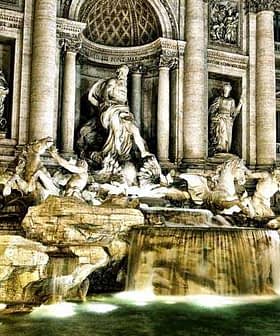 Trevi Fountain in Rome featuring sculptures and flowing water illuminated at night. - Olive Oil Times
