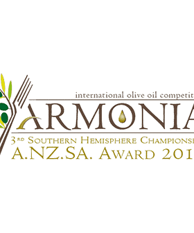 Logo for the Armonia International Olive Oil Competition featuring olive branches and a droplet. - Olive Oil Times