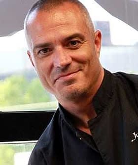 Portrait of a chef named Juan Pablo wearing a black chef's jacket and smiling at the camera. - Olive Oil Times