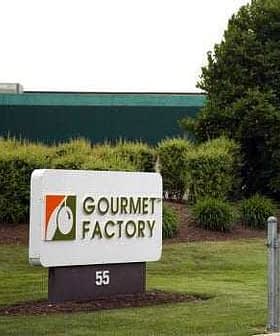 Sign for Gourmet Factory located at 55, featuring a logo and text on a white background. - Olive Oil Times