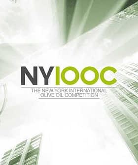 Logo for the New York International Olive Oil Competition featuring text and a cityscape design. - Olive Oil Times