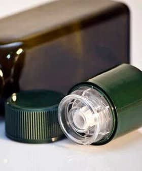 Green plastic bottle with a removable cap placed next to it on a white surface. - Olive Oil Times
