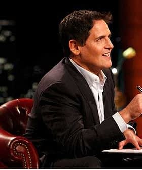 A man in a suit sitting on a leather chair, holding a pen and looking thoughtfully. - Olive Oil Times