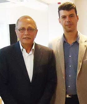 Two men standing side by side, both wearing formal attire, with one in a dark suit and the other in a light-colored blazer. - Olive Oil Times