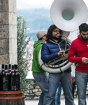 Three musicians performing outdoors with a tuba, trumpet, and other instruments. - Olive Oil Times