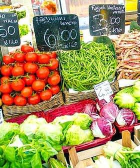 Display of fresh vegetables including tomatoes, green beans, and lettuce at a market stall. - Olive Oil Times