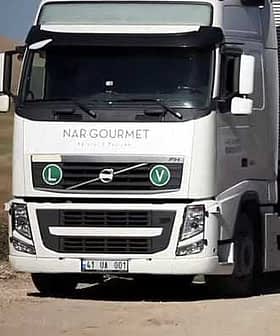 White Volvo truck with Nargourmet branding and green circular symbols on the front. - Olive Oil Times