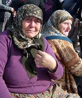 Two women wearing headscarves, one with a distressed expression and the other looking away. - Olive Oil Times