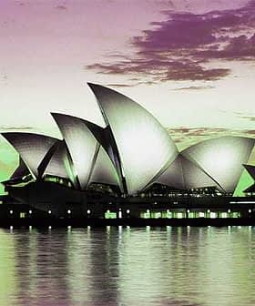 Sydney Opera House with its iconic sail-like structures reflected in the water at dusk. - Olive Oil Times