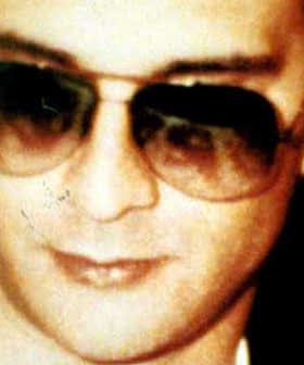 Close-up image of a man wearing dark sunglasses with a neutral expression. - Olive Oil Times