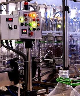 Control panel with buttons and indicators on a bottling machine in a production facility. - Olive Oil Times