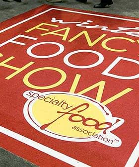 Red carpet with the text 'Winter Fancy Food Show' and 'Specialty Food Association' in yellow and white. - Olive Oil Times