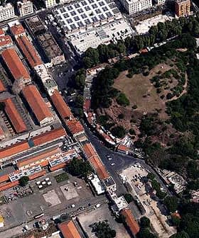 Aerial view showing a mix of buildings and a green park area in an urban setting. - Olive Oil Times