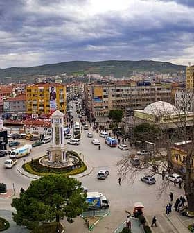 Aerial view of a Turkish town featuring a clock tower and surrounding buildings. - Olive Oil Times