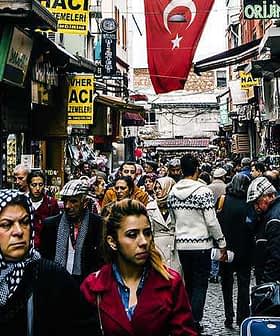 A bustling street in Turkey filled with people walking and shops lining the sides. - Olive Oil Times