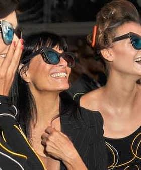 Three women smiling and wearing sunglasses at an event, showcasing various styles of eyewear. - Olive Oil Times