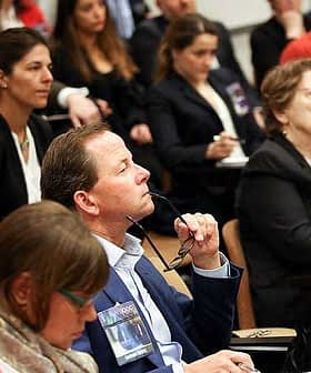 A diverse group of individuals seated in an audience during a conference or seminar event. - Olive Oil Times