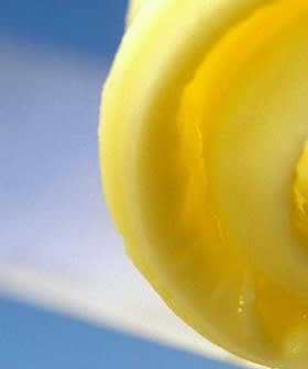 Close-up view of a swirl of olive oil gel against a blue background. - Olive Oil Times