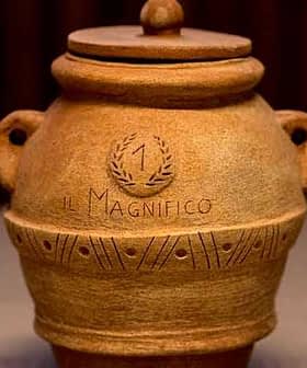 Ceramic pot with a lid, featuring engraved text and decorative patterns on the surface. - Olive Oil Times