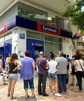 Customers waiting in line outside a Eurobank branch in a city setting. - Olive Oil Times