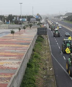 Multiple tractors driving on a highway with vehicles in the background. - Olive Oil Times