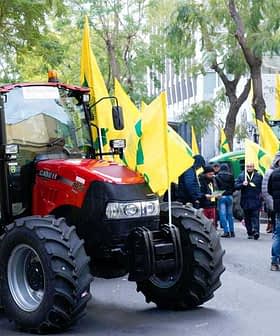 A red tractor parked on a street with yellow flags during a protest gathering. - Olive Oil Times