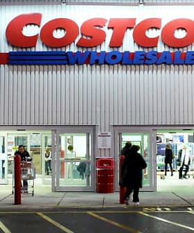 Exterior view of a Costco Wholesale store with customers entering and exiting. - Olive Oil Times