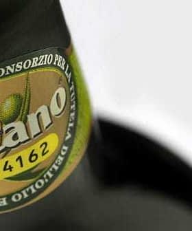 Close-up of a Toscano IGP olive oil bottle label featuring green olives and certification details. - Olive Oil Times