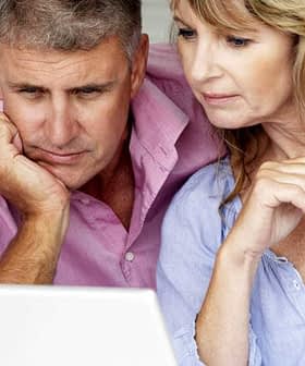 Middle-aged couple closely examining content on a laptop screen in a home setting. - Olive Oil Times
