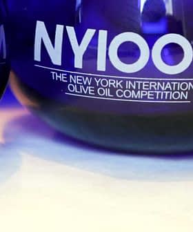 Blue glass awards for the New York International Olive Oil Competition with the text 'NYIOOC'. - Olive Oil Times