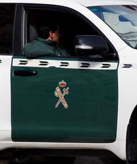 A Guardia Civil vehicle parked with a visible officer inside, featuring a green and white color scheme. - Olive Oil Times