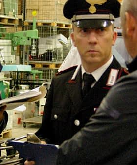 Two Italian Carabinieri officers inspecting a facility with documents and equipment. - Olive Oil Times