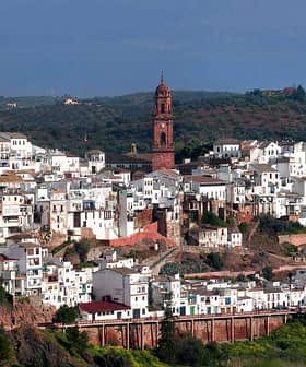 Panoramic view of Montoro, a village with white buildings and a prominent clock tower in the background. - Olive Oil Times