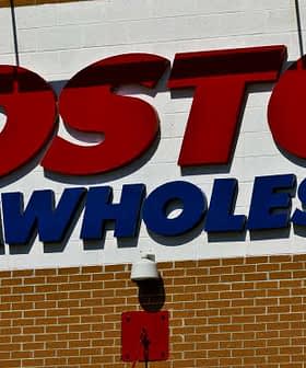 Sign displaying the Costco Wholesale logo on a brick wall. - Olive Oil Times