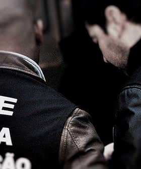 Two ASAE police officers in uniform with visible text on the back of their jackets. - Olive Oil Times