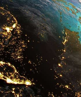 Satellite view of Earth at night showing illuminated regions and landmasses. - Olive Oil Times