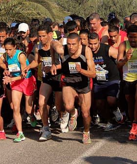 Group of runners starting a race, wearing various athletic gear and bib numbers. - Olive Oil Times