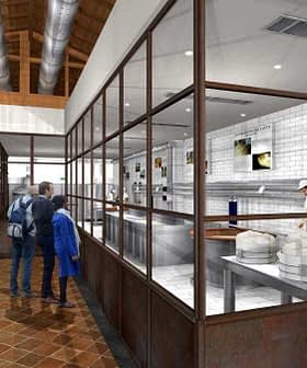 Interior view of a cheese production facility with workers and visitors observing the process. - Olive Oil Times