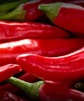 A close-up view of fresh red chili peppers stacked together. - Olive Oil Times