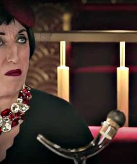 Woman seated at a restaurant wearing a black dress and a large statement necklace with red and silver accents. - Olive Oil Times