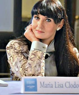 Maria Lisa Clodoveo seated at a table with her nameplate in front of her during an event. - Olive Oil Times