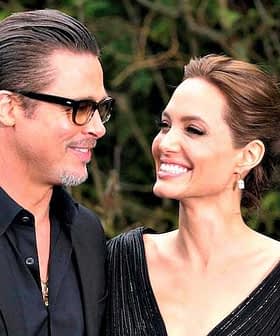 A couple smiling at each other while attending an event, both dressed in formal attire. - Olive Oil Times