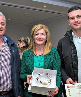 Three individuals posing with awards and a certificate at an event. - Olive Oil Times