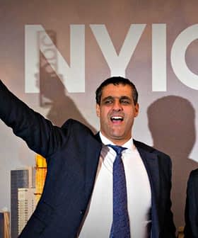 A man in a suit holding an award while standing next to another man in formal attire at an event. - Olive Oil Times