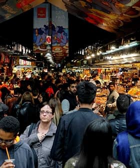 A busy marketplace filled with people browsing various stalls and displays of goods. - Olive Oil Times