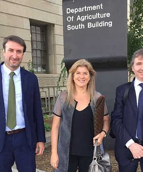 Three individuals standing in front of the Department of Agriculture South Building sign. - Olive Oil Times