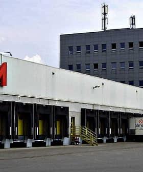 Exterior view of the Konzum distribution center with loading docks and delivery trucks. - Olive Oil Times