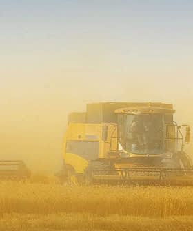 Two combine harvesters working in a field surrounded by dust during harvest season. - Olive Oil Times